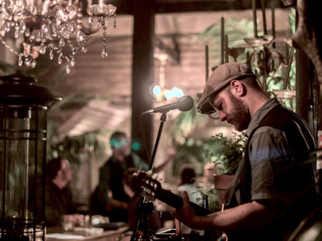 A musician with a guitar at a microphone